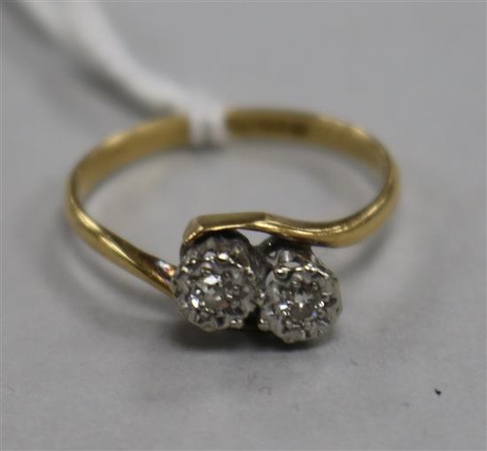 An 18ct gold and platinum, two stone illusion set diamond crossover ring, size N.
